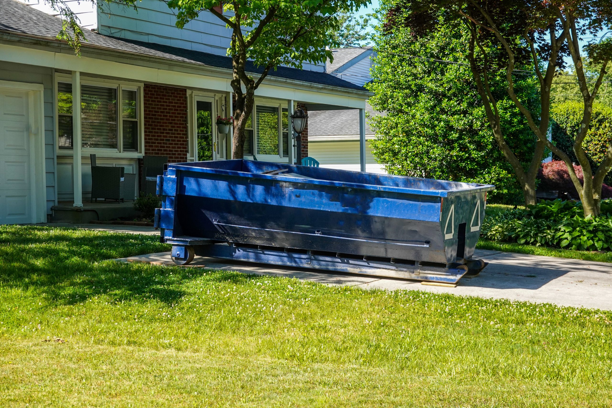 A small blue RoRo in the driveway of a house in a residential neighbourhood