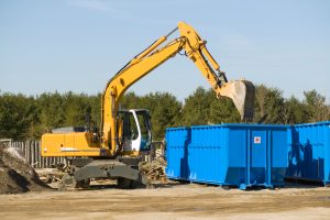demolition bulldozer dropping waste into a roro skip